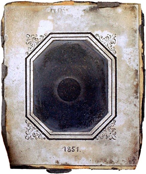 Berkowski's daguerreotype of the eclipsed Sun, a dark disc with a pale glow of corona around it, in its worn octagonal mount marked 1851.