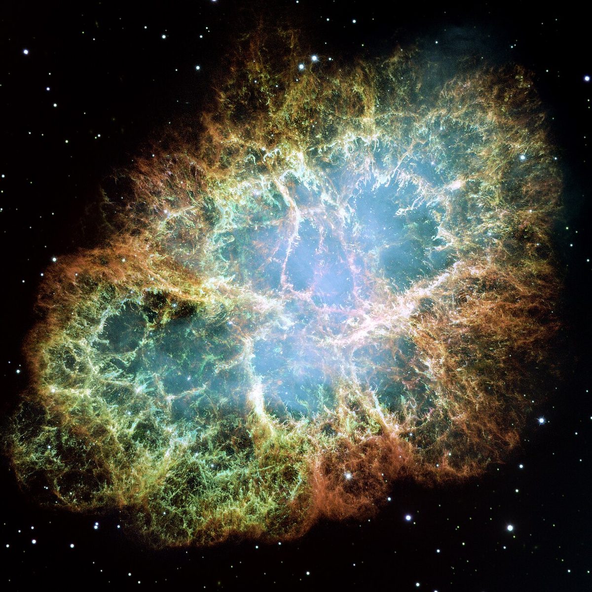 The Crab Nebula, a glowing cloud of orange and blue filaments, photographed by the Hubble Space Telescope.