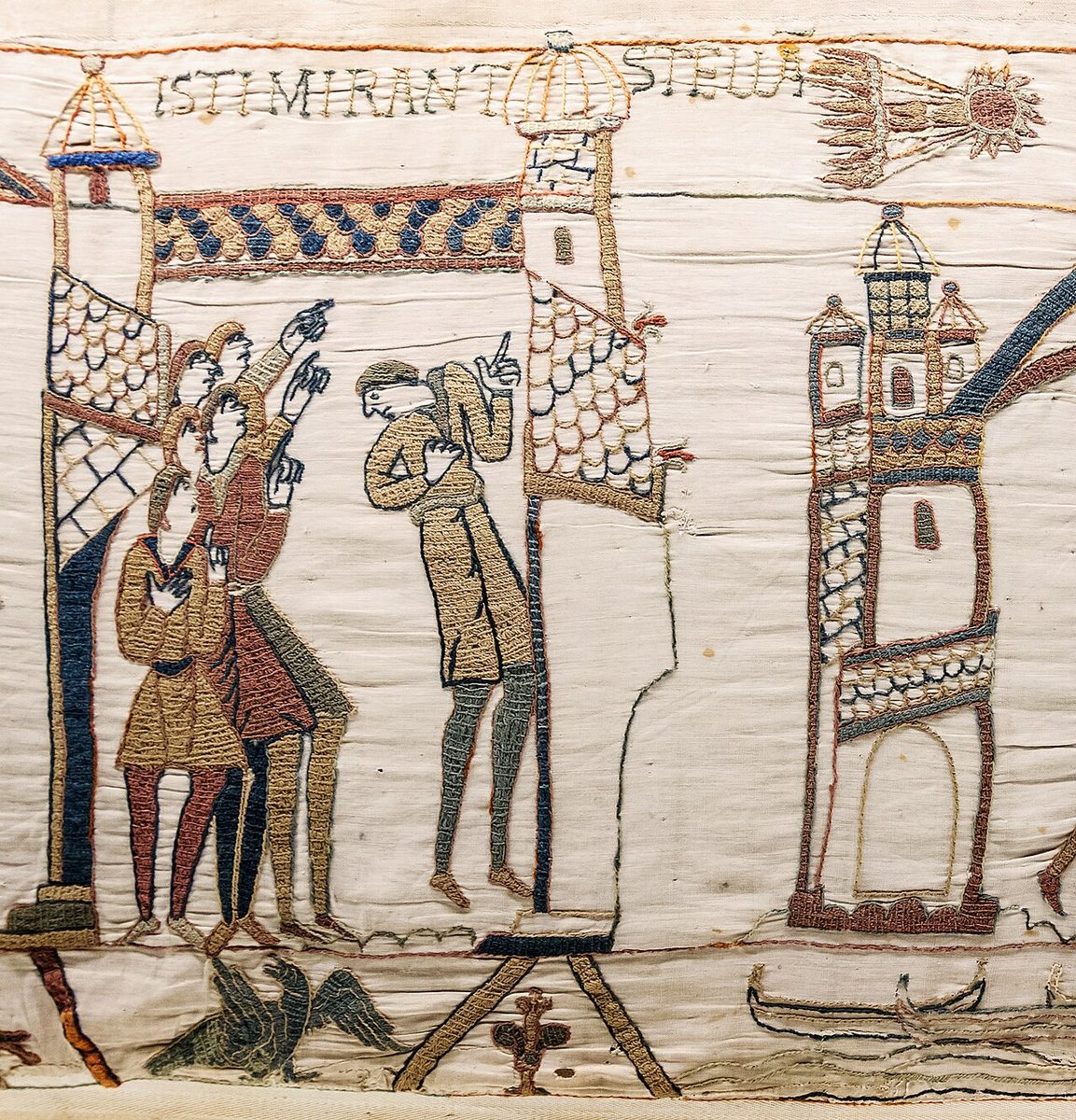 A scene from the Bayeux Tapestry in which a group of men point up at Halley's Comet, under the words ISTI MIRANT STELLA.