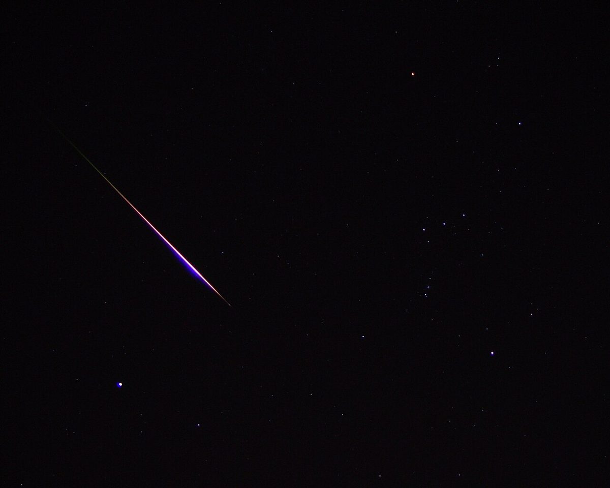A bright Leonid meteor streaks across a starry sky near Orion, November 2001.