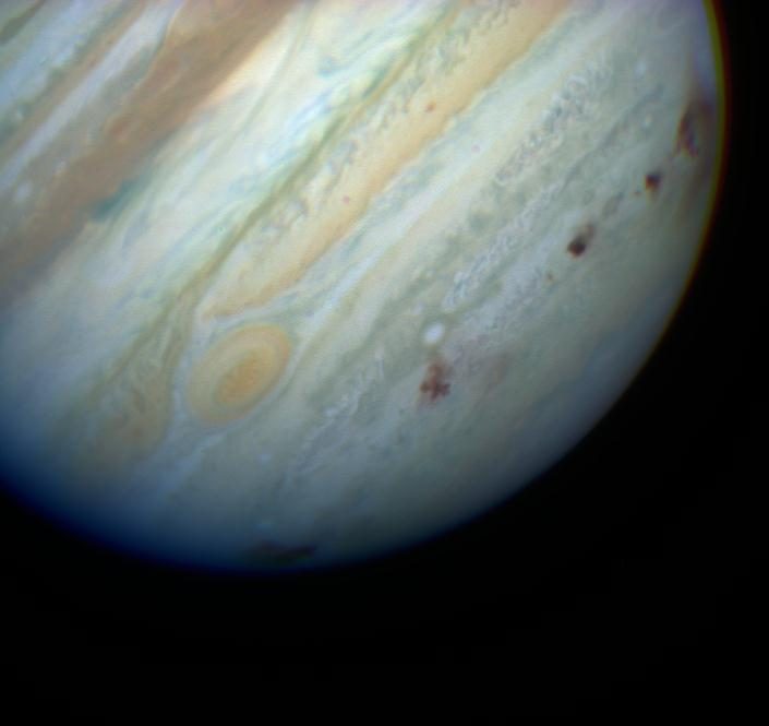 Jupiter's banded clouds with a row of dark impact scars left by fragments of Comet Shoemaker-Levy 9.