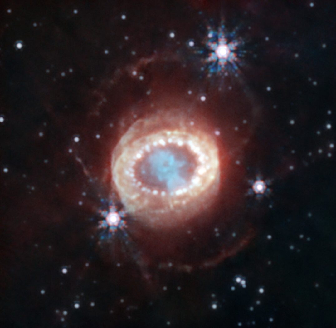 The remnant of Supernova 1987A, a glowing ring around a blue keyhole-shaped core, seen by the James Webb Space Telescope.