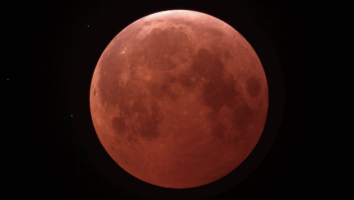 The Moon glows deep copper red in Earth's shadow during a total lunar eclipse.