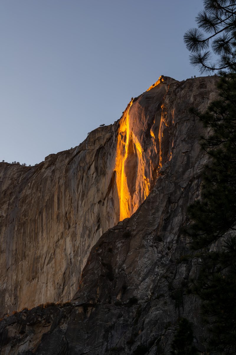 Horsetail Fall glows orange like lava in the last sunlight as it pours down the face of El Capitan.